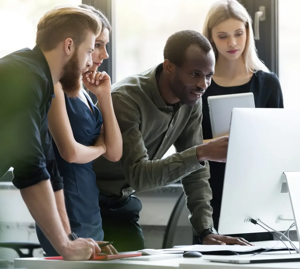 Group of young businesspeople in a meeting at office using computer